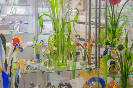 Flowers of glass and crystal. Souvenirs in St. Petersburg. Beautiful storefront colors of glass. Jugs and pots for flowersの写真素材