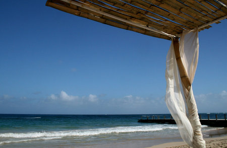 A quaint bamboo canopy offers shelter from the sun on a Caribbean beach.の写真素材