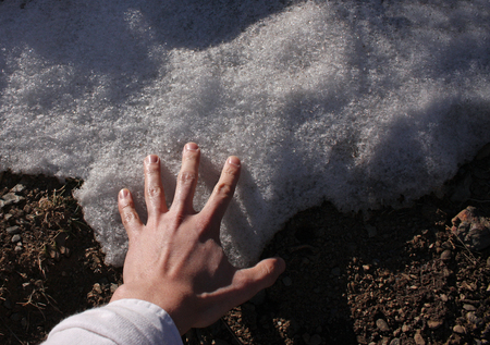 Man touching the first snow on the floorの写真素材