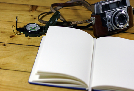 An empty travel journal with old-fashioned camera and compassの写真素材