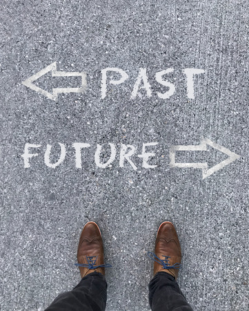 Man standing in front of two arrows and the words "Past" and "Future"の写真素材
