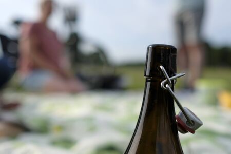 Picnic after a bike tour: Young happy couple on a picnic with a bottle of beer in the foregroundの写真素材