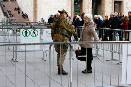 Milan, Italy - December 14, 2018: A senior woman is frisked by a soldier wearing a camouflage...