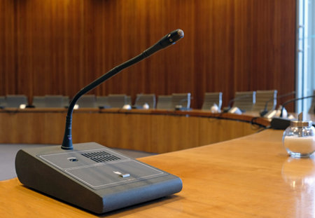 Conference room with wooden walls and microphones at each seat