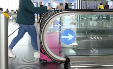 09 February 2020 - Barcelona Spain: A female tourist walks onto a conveyor belt at the airport of Barcelona.の写真素材