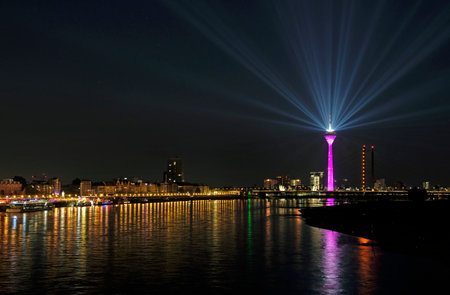 D?sseldorf, Germany - 20 June 2020: A light show with spotlights from D?sseldorf's "Rheinturm" tower illuminates the night sky over the city.のeditorial素材
