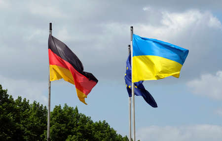 The flags of Ukraine, Germany, and the EU waving in the windの写真素材