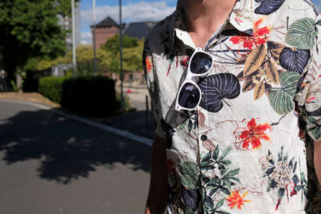 Man wearing a hawaiian shirt with a pair of white sunglasses tucked inの写真素材