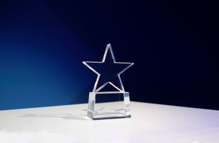 Star-shaped award on a table with spotlights and copy space