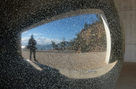 Man reflected in a bit marble sphere on Naoshima, Japan
