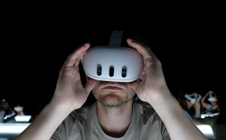 Man wearing virtual reality headset in a dark room