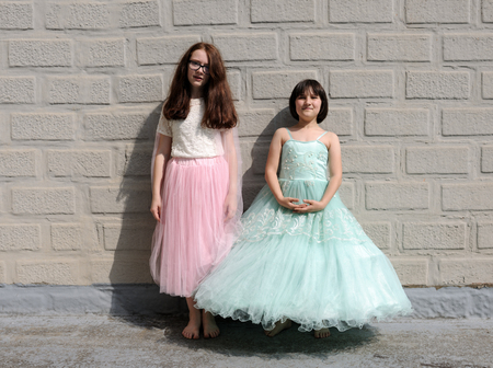 portrait of cute little girls on a brick wall backgroundの写真素材