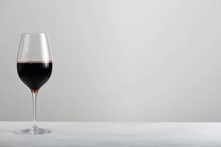 Glass with red wine on grey backgroundの写真素材