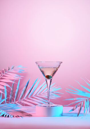 Martini cocktail with palm leaves on pink illuminated backgroundの写真素材