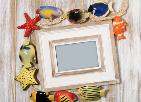 Picture frame with decorative fishes on wooden backgroundの写真素材