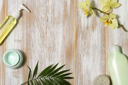 Frame of beauty products with orchid and leaves on wooden backgroundの写真素材