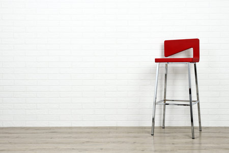 Modern red chair on white brick wall background