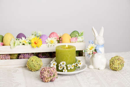 Arrangement of candle, rabbit and multicolored Easter eggsの写真素材