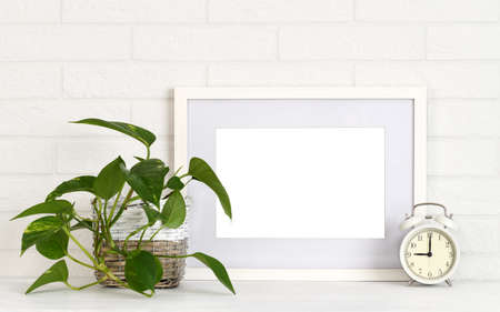 Mock up picture frame with houseplant and alarm clockの写真素材