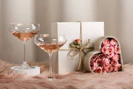 Two glasses with rose wine and decorated giftsの写真素材