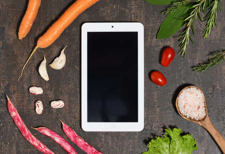 Tablet mock up with food ingredients on wooden backgroundの写真素材