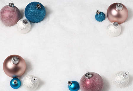 Arrangement of beautiful baubles on snow backgroundの写真素材