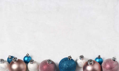 Arrangement of beautiful baubles on snow backgroundの写真素材