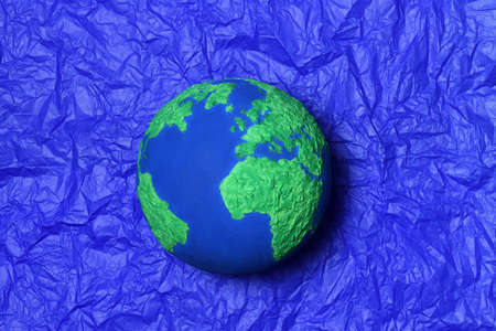 Handmade Earth model on a blue paper backgroundの写真素材