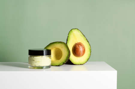 Cream jar with avocado on green backgroundの写真素材