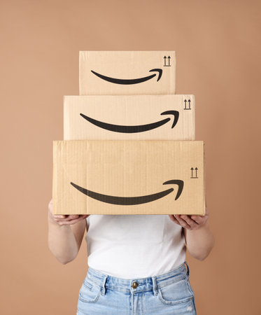 Woman holding Amazon cardboard boxes. Bergamo, Italy, 17 December 2022.のeditorial素材