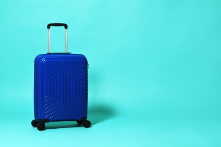 Blue trolley travel bag on mint backgroundの写真素材