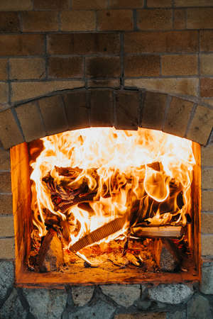 Fire burns in a brick fireplace. Close-up photo of a flame. Home comfort. High quality photoの写真素材