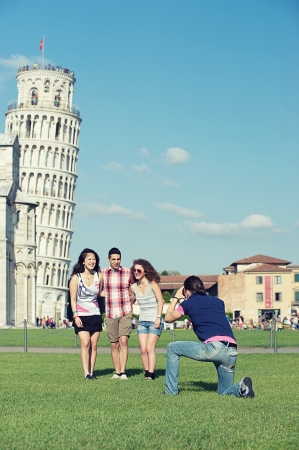 Group of Friends Taking Photo with Pisa Leaning Tower on Background , Italyの写真素材