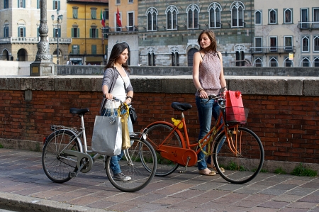 Two Beautiful Women Walking in the City with Bicycles and Bags,Italyの写真素材