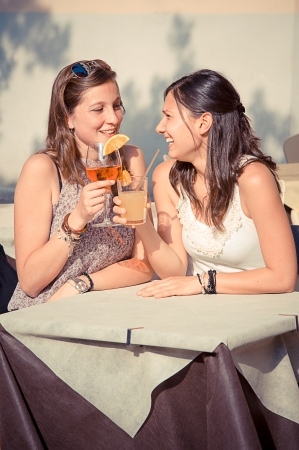 Two Young Women Cheering with Cold Drinks,Italyの写真素材