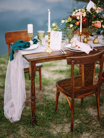 Dining table with floral decoration and festive table setting outdoor, seascape viewの写真素材