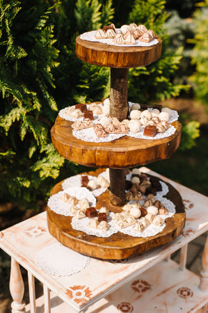 Wooden candy bar at outdoor wedding celebration, catering table in rustic style