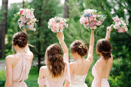 Bridesmaids in pink dresses and bride holding beautiful bouquets. Beautiful luxury wedding blog concept. Summer wedding.の写真素材