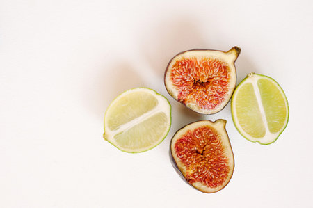 Lime and figs isolated on white background. Fresh natural looking fruits. Top view, flat lay.