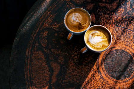Two cups of coffee on brown vintage table with beautiful latte art. Top viewの写真素材
