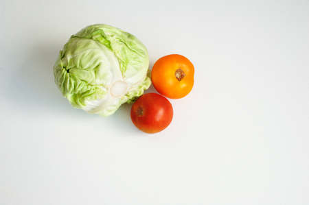 White cabbage head and two red tomatoes isolated on white background one whole head with copy space.の写真素材