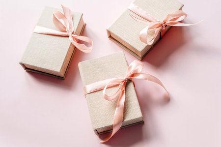 Christmas presents. Set of gift boxes with pastel ribbons on pink background, top view, flat lay.