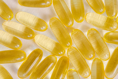 Fish oil capsules close-up, top view. Omega nutrition, vitamin pills on neutral backdrop. Medical...