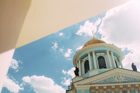 Sumy, Ukraine: Bottom view of an Ukrainian church dome on blue sky background. Bright summer sunny day. Orthodox cathedral with figures and columnsの写真素材