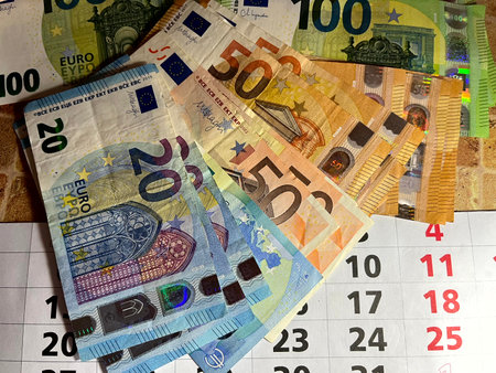 Euro banknotes of different denominations on a calendar with a date, the concept of saving moneyの写真素材