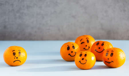 Tangerine with painted faces, citrus, mandarin emoji, concpt of bullyingの写真素材