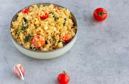 Quinoa with tomatoes, spinach and garlic in a bowl. Vegetarian recipe, healthy lifestyle.の写真素材