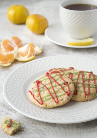 Three Christmas cookies and a cup of tea, some mandarin on backgroundの写真素材