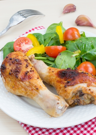 Two roasted chicken legs with vegetable saladの写真素材