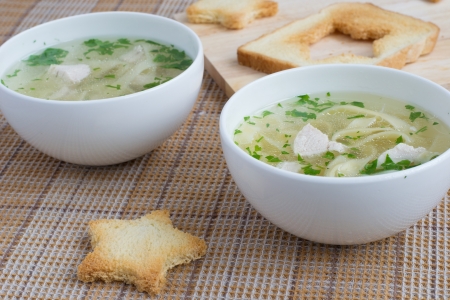 Chicken soup served with noodles, parsley and toastsの写真素材
